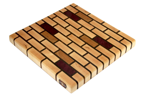 medium maple brick pattern end grain cutting board with cherry and purple heart accents.