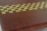 close up of Finish line pattern cutting board with padauk and maple wood on white background